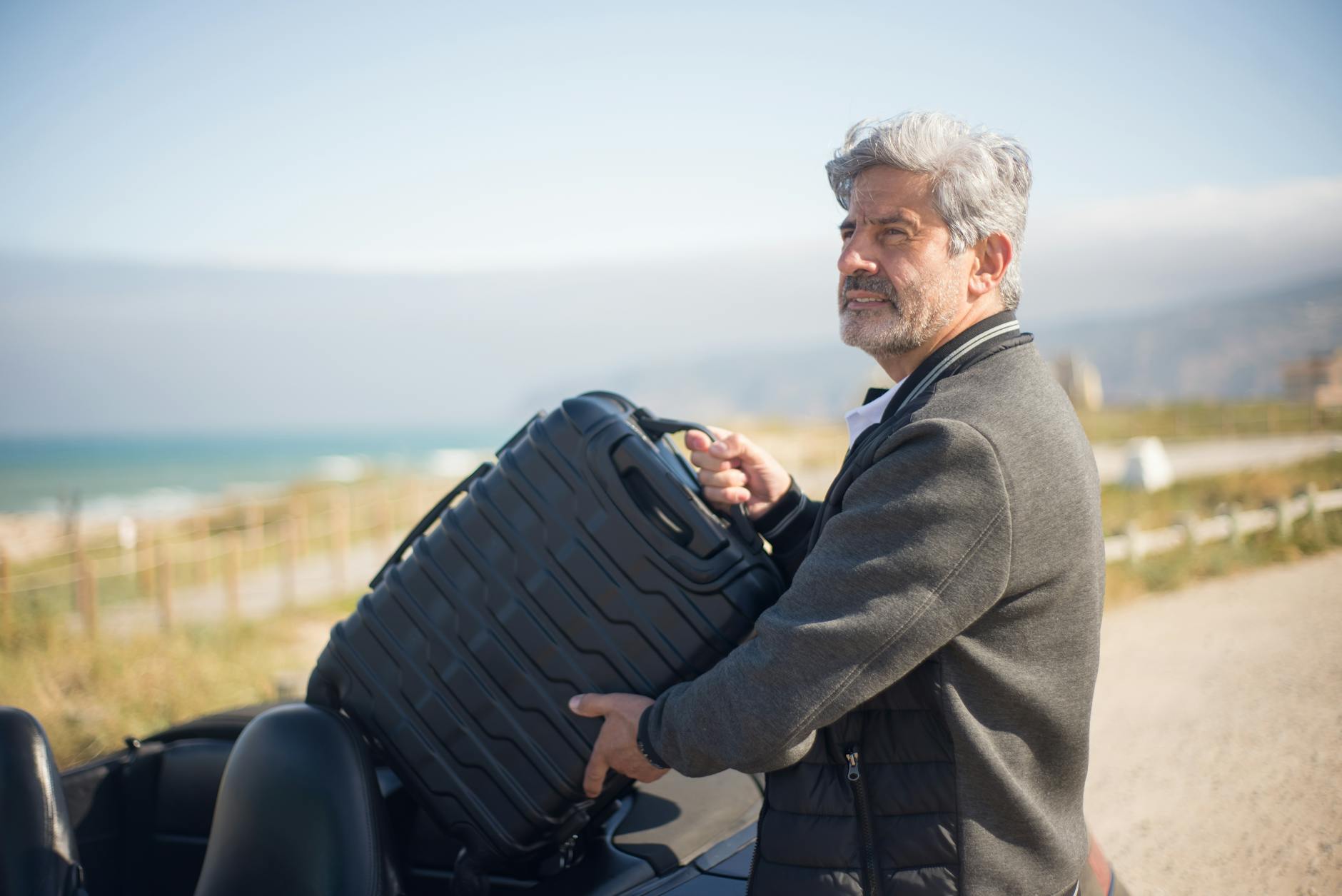 Older man traveling alone on a scenic coastal road trip